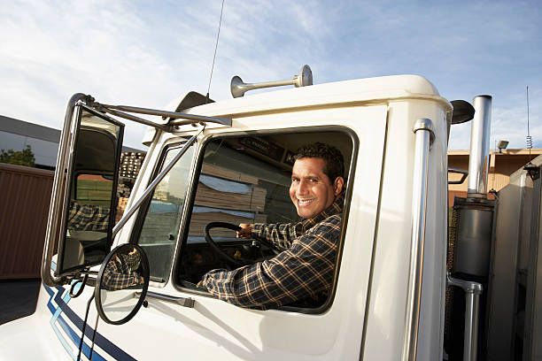 Smiling truck driver behind the wheel of a white cab